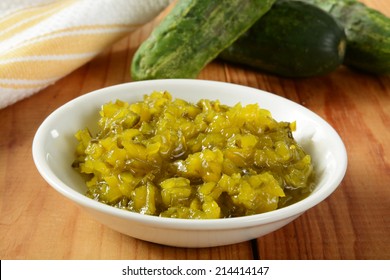 A Bowl Of Relish With Kirby Pickling Cucumbers In The Background