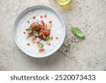 Bowl of rice porridge with figs and pomegranate, flat lay on a beige granite background, horizontal shot with space