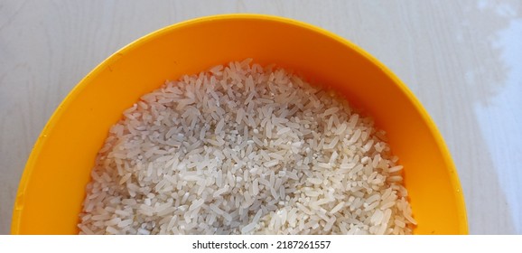 a bowl of rice ready to be cooked on an orange stool