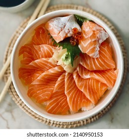 A bowl of rice with salmon sashimi, ikura, wasabi, pickled ginger and shiso leaf on top also called Salmon don. Japanese food and take Delivery food concept. - Powered by Shutterstock