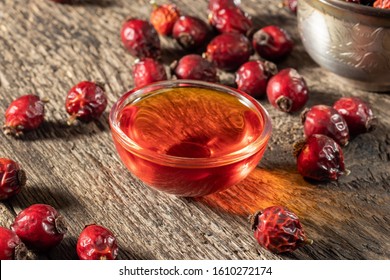 A Bowl Of Rosehip Seed Oil With Dried Berries