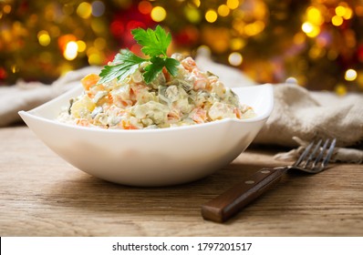 bowl of russian salad olivier with meat and vegetables on a wooden table - Shutterstock ID 1797201517