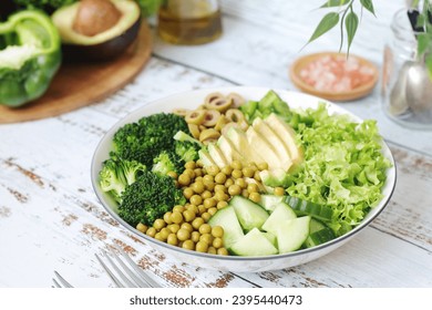 A bowl with a salad made of green vegetables - Shutterstock ID 2395440473