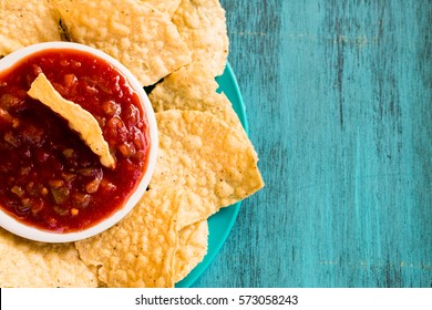 Bowl Of Salsa And Tortilla Chips On Blue Background
