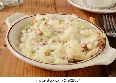 A Bowl Of Scalloped Potatoes With Cheese Sauce And Ham