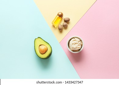 Bowl With Shea Butter, Essential Oil And Avocado On Color Background