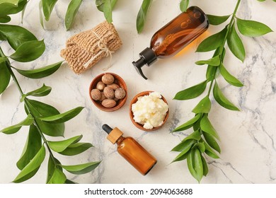 Bowl Of Shea Butter, Nuts, Bath Supplies And Plant Branches On Light Background