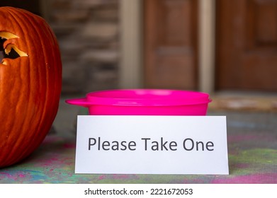 Bowl Sitting On A Doorway With A Sign Stating To Please Take One For Halloween Trick Or Treaters. 
