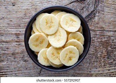 Bowl Of Sliced Banana On Wooden Background, Top View