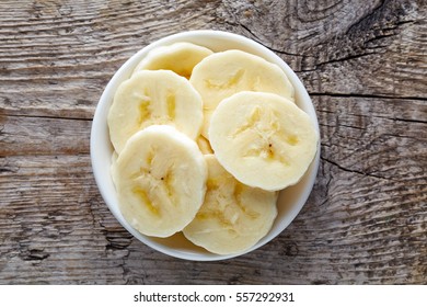 Bowl Of Sliced Banana On Wooden Background, Top View