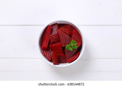 bowl of sliced and pickled beetroot on white wooden background