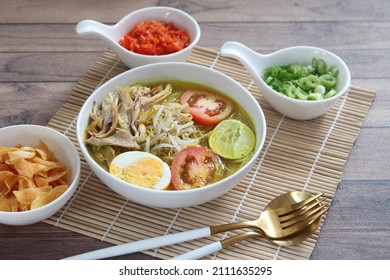 A bowl of Soto ayam. " Soto Ayam " is a traditional Indonesian food with yellow chicken broth, containing rice vermicelli ,bean sprouts, shredded chicken, egg, and sliced ​​tomatoes. 