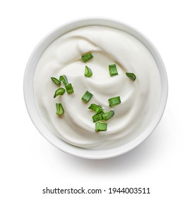 bowl of sour cream with green onions isolated on white background, top view
