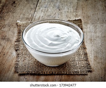 Bowl Of Sour Cream On Old Wooden Table