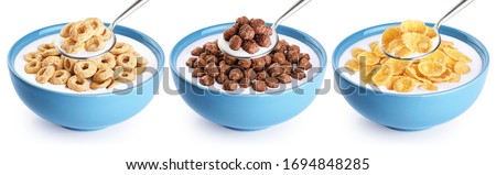 Bowl and spoon with corn rings, balls, cornflakes and yogurt isolated on white background. Cereals breakfast collection with clipping path.