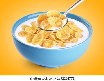 Bowl and spoon with cornflakes, milk, yogurt on orange background. With clipping path.