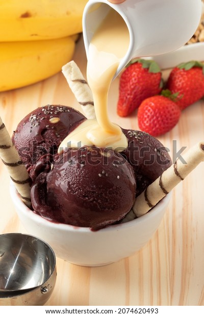 A bowl of açaí, strawberry, banana and condensed\
milk, selective focus