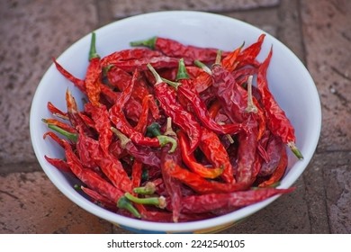 A bowl of sun dried Red Hot Cile Pepers on paving