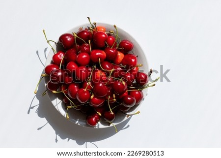 A bowl of sweet cherries on a white table, sweet berry, summer harvest