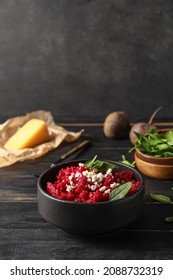 Bowl with tasty beet risotto on dark wooden background