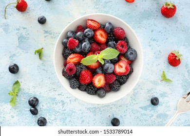 Bowl With Tasty Berry Salad On Color Background