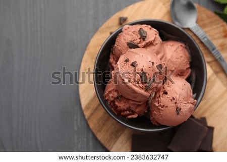 Bowl with tasty chocolate ice cream on wooden board, flat lay. Space for text