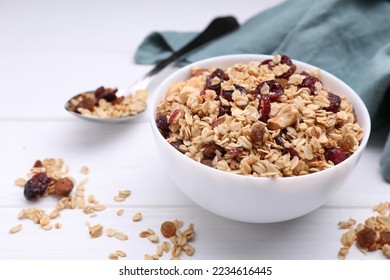 Bowl of tasty granola on white wooden table