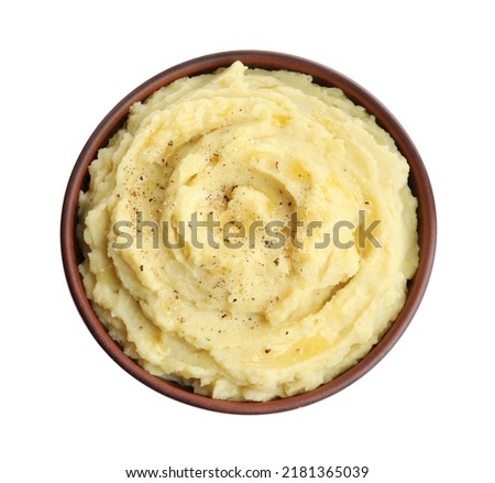 Bowl of tasty mashed potatoes with black pepper isolated on white, top view