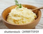 Bowl of tasty mashed potatoes with fresh dill served on wooden table