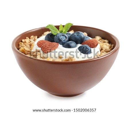 Bowl of tasty oatmeal with blueberries, yogurt and almond on white background