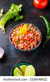 Bowl Of Tasty Pico De Gallo Salsa On Dark Background. Pico De Gallo Salsa And Ingredients. Mexican Food Concept