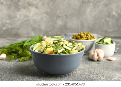 Bowl of tasty Potato Salad with vegetables on grunge background - Shutterstock ID 2314951473