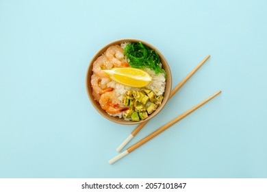 Bowl with tasty rice, shrimps and vegetables on color background