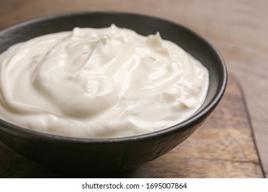 Bowl Of Tasty Sour Cream On Wooden Table, Closeup