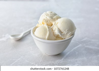 Bowl with tasty vanilla ice cream on light background
