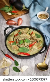 Bowl of Thai traditional green curry with lamb and eggplant with spices and its ingredients such as shallot, garlic,sweet basilic and red chili.The flavor base is curry paste&coconut milk          