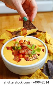 Bowl Of Thick Creamy Queso Cheese Dip With Bacon, Peppers And Tomatoes And Tortilla Chips
