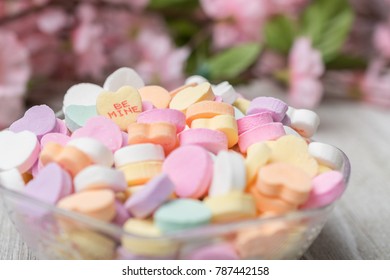 Bowl of valentines heart candy with messages.  Focus is on Be Mine.