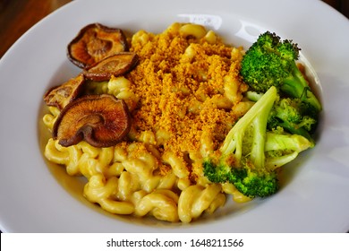 A Bowl Of Vegan Mac And Cheese With Broccoli And Mushrooms