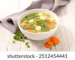 bowl of vegetable broth and herbs