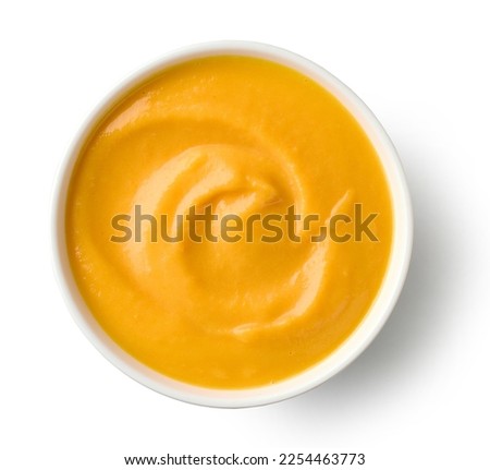 bowl of vegetable cream soup isolated on white background, top view