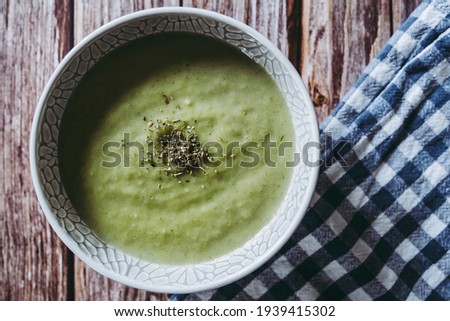Bowl of velvety leek soup with basil on kitchen table