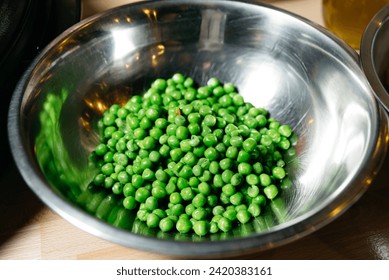 A bowl of vibrant green peas reflecting healthy eating and fresh produce, an essential ingredient for nutritious meals. - Powered by Shutterstock