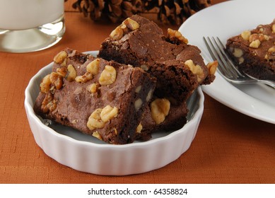 A Bowl Of Walnut Brownies And A Glass Of Milk