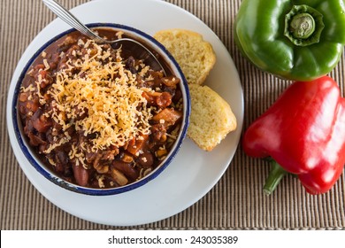 Bowl Of Warm Chili Winter Comfort Food Dinner With Corn Bread Muffin Red And Green Peppers