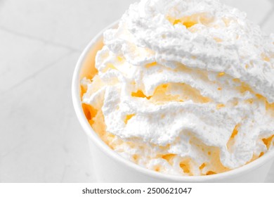 Bowl of whipped cream  with ice cream isolated on white marble  background from close-up view