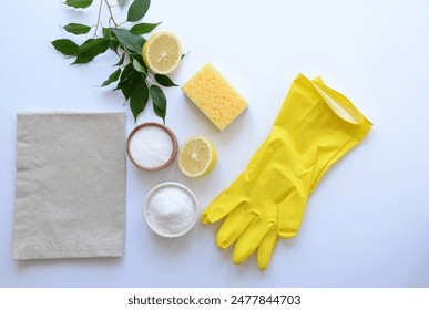 bowl whith salt and washing soda, yellow sponge, grey napkin, yellow latex gloves, half of lemon , green plant on the blue background. eco concept cleaning, natural - Powered by Shutterstock