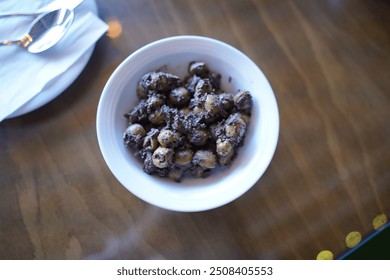 A bowl of Zeytoon Parvardeh, a popular Persian appetizer made with marinated olives, herbs, and spices, offering a tangy and savory taste that's a staple in Iranian cuisine. - Powered by Shutterstock