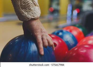 Bowling accessories background. Interior of bowling alley, lane with hand taking ball, selective focus