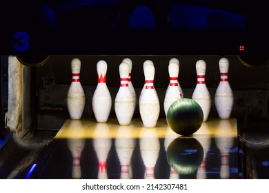 Bowling Alley. Green Bowling Ball Rolling Into The Pins.